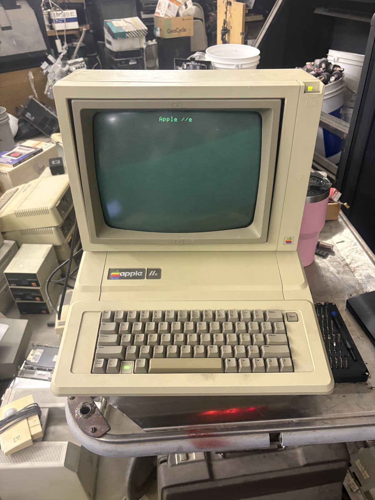 An Apple IIe, part of the Apple II family, on a workbench.