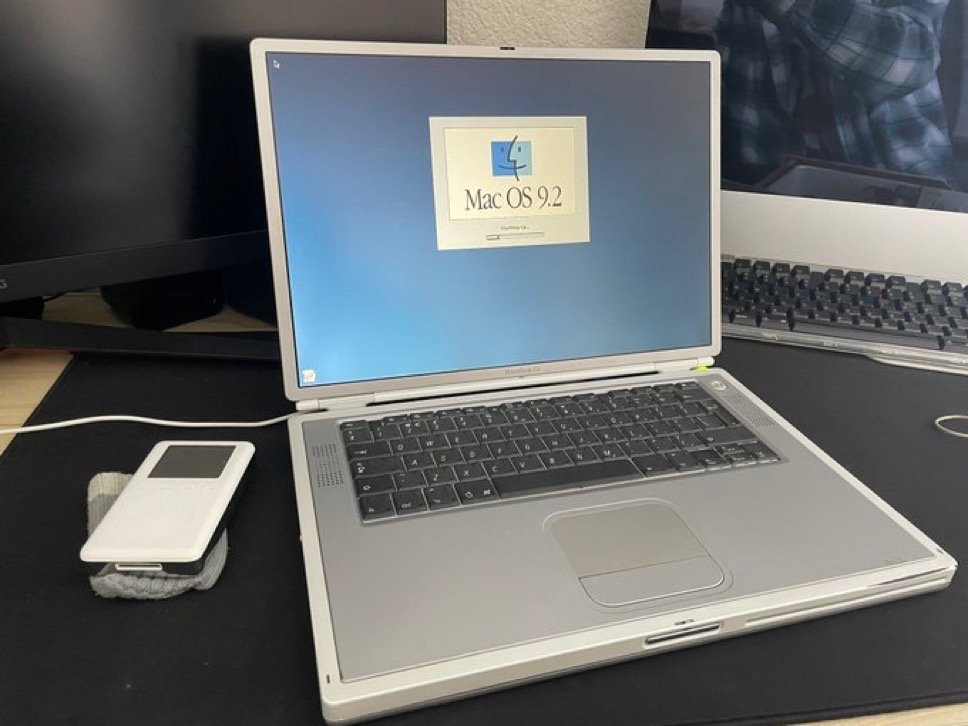 The titanium PowerBook starting Mac OS 9.2 beside an iPod.